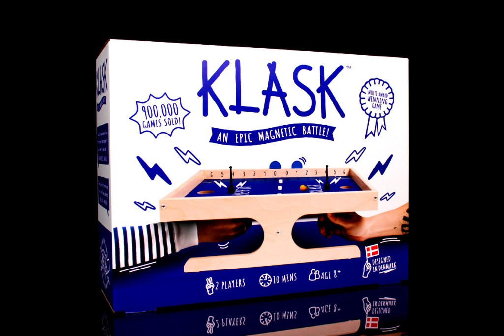 KLASK board game box featuring the title, player and game duration details, alongside playful design elements.
