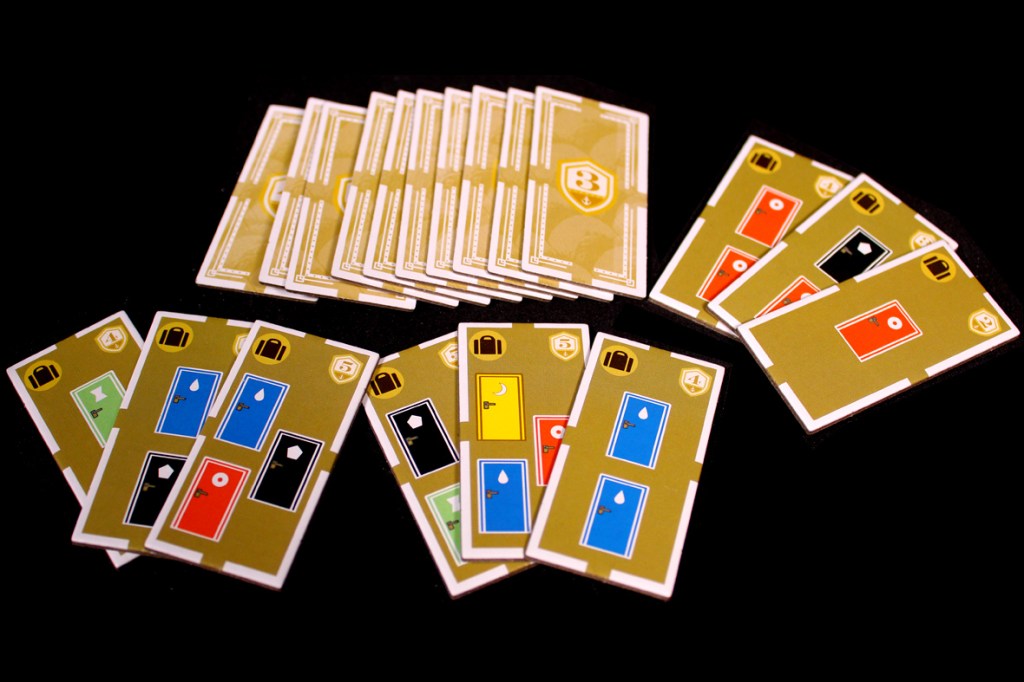 A collection of game cards featuring various room designs in different colors, including blue, green, red, and black, displayed on a dark background.