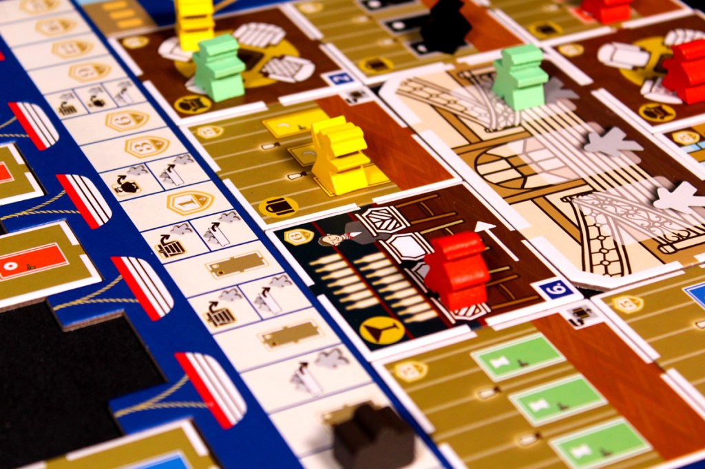 A close-up view of the board game 'Come Sail Away!', showcasing colorful player pieces, numbered rooms, and various game components laid out on the game board.