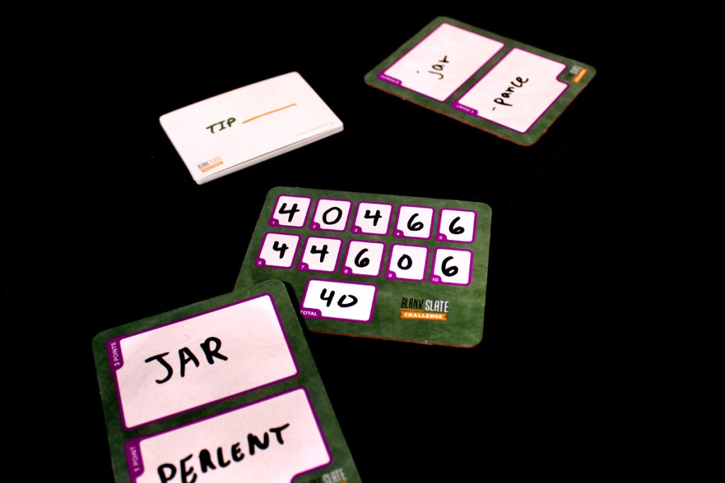 A close-up of the Blank Slate Challenge game setup showing a tip card, player scorecards with words 'JAR' and 'PEARLENT', and a score tracker.