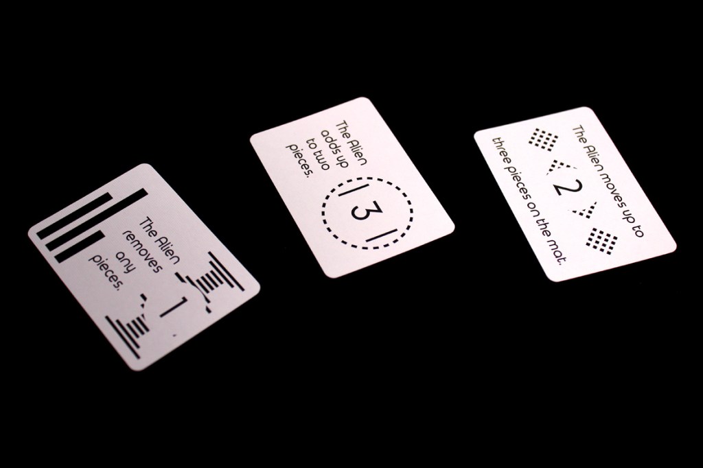 Three game cards displaying alien movement and action instructions, featuring minimalistic designs with black text on a white background.