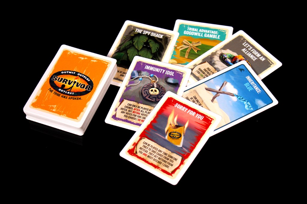 A collection of game cards from Survivor: The Tribe Has Spoken, featuring the game's logo and various action cards, displayed on a black background.