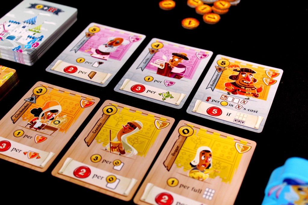 An assortment of Castle Combo game cards arranged on a black surface, showcasing various character illustrations and their corresponding abilities.