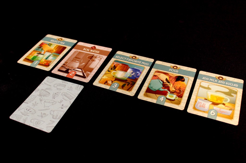 A set of colorful cards depicting steps to make tea, including selecting tea, boiling water, selecting a favorite mug, pouring, and adding milk and sugar. A background card features a pattern of tea-related items.