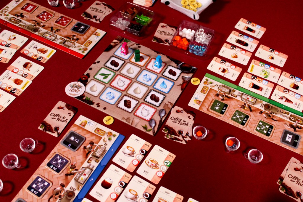 An overview of the board game Coffee Rush, with player boards, ingredient tokens, and order cards displayed on a red surface.