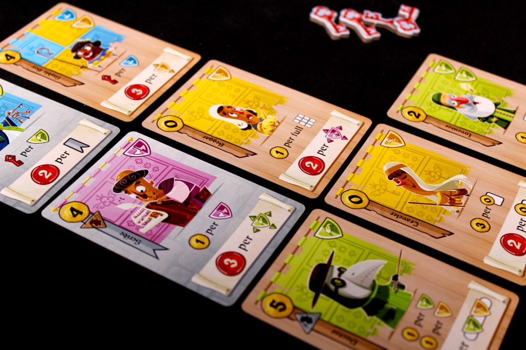 Gameplay cards from the board game Castle Combo, featuring colorful illustrations and various scoring icons on a dark background.