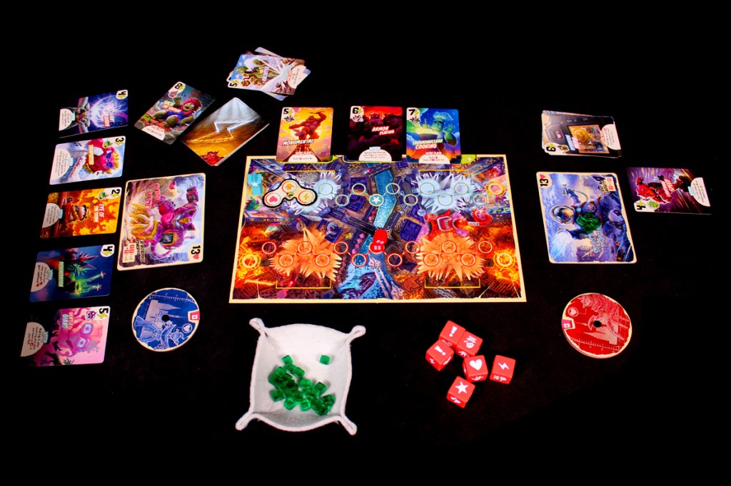 A tabletop game setup for King of Tokyo: Duel, featuring a colorful game board, cards, dice, and tokens displayed on a black surface.