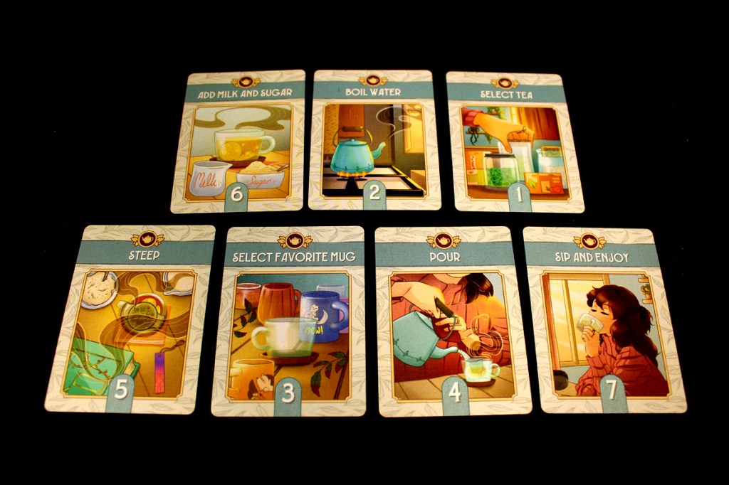 A flat lay of tea preparation cards from the game 'A Nice Cuppa', displaying instructions for making tea, including steps like 'Add Milk and Sugar', 'Boil Water', 'Select Tea', 'Steep', 'Select Favorite Mug', 'Pour', and 'Sip and Enjoy'.