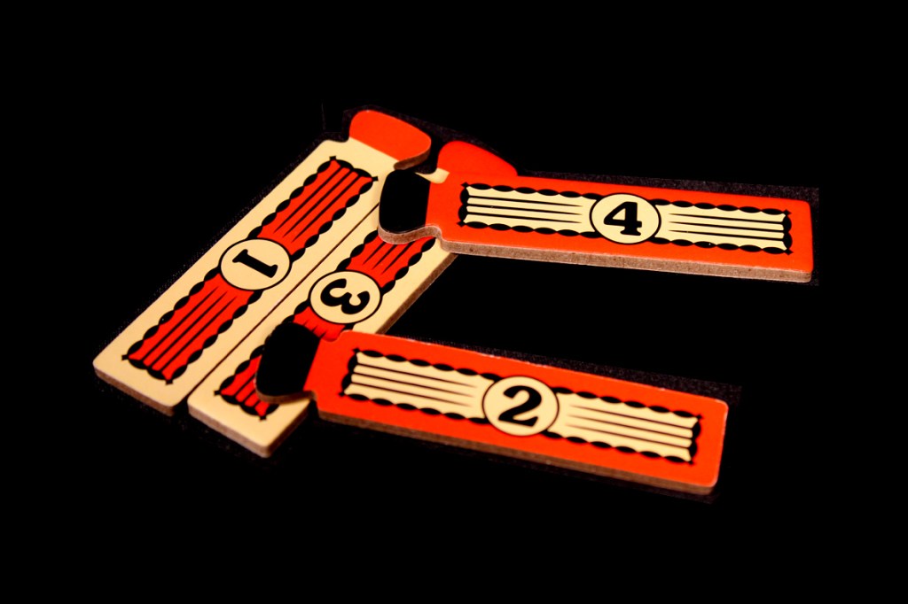Wooden tokens with numbers 1, 2, 3, and 4, displayed against a black background.
