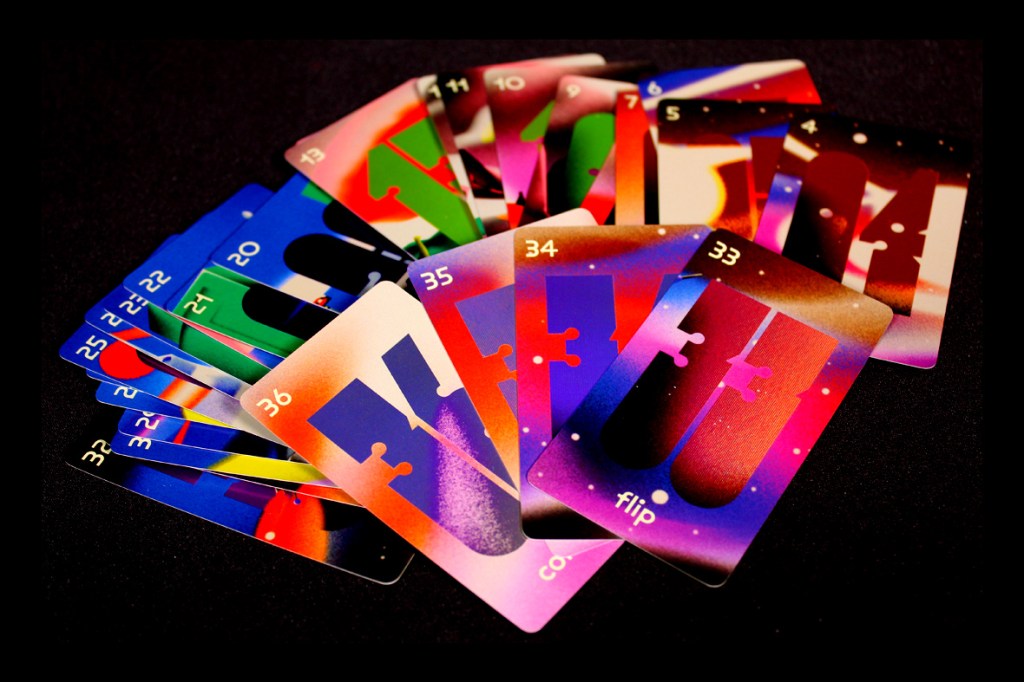 A collection of colorful cards from the board game 'Time to Panic,' featuring various designs, numbers, and a unique art style, arranged in a fan-like display.