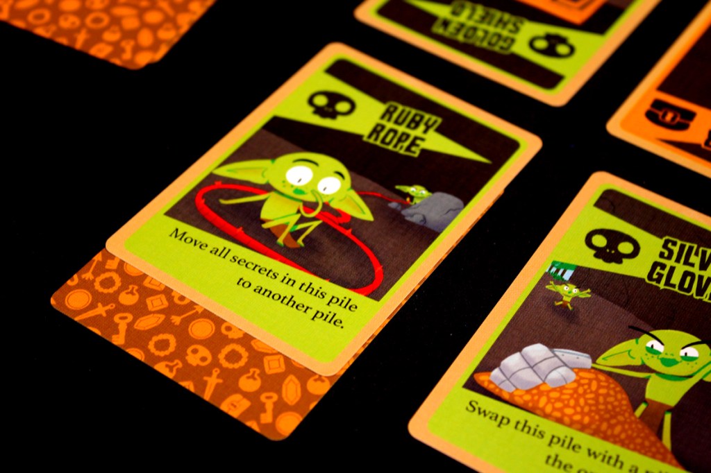 A close-up of game cards from 'Squabblin Goblins', featuring the 'Ruby Rope' and 'Silver Gloves' cards with illustrations of goblins and gameplay instructions.