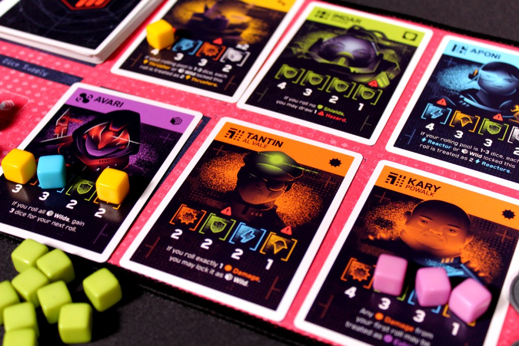 Close-up of gameplay elements from Moonrollers board game, featuring character cards and colorful tokens.