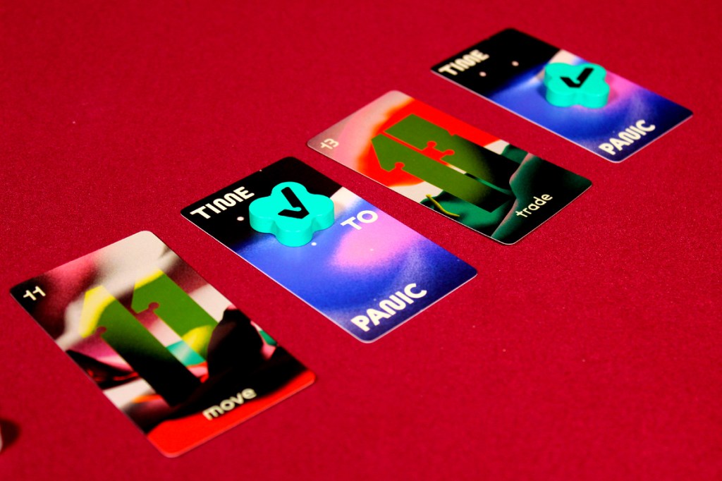 Close-up of cards from the board game 'Time to Panic', featuring actions like 'move' and 'trade', along with a colorful background and token.