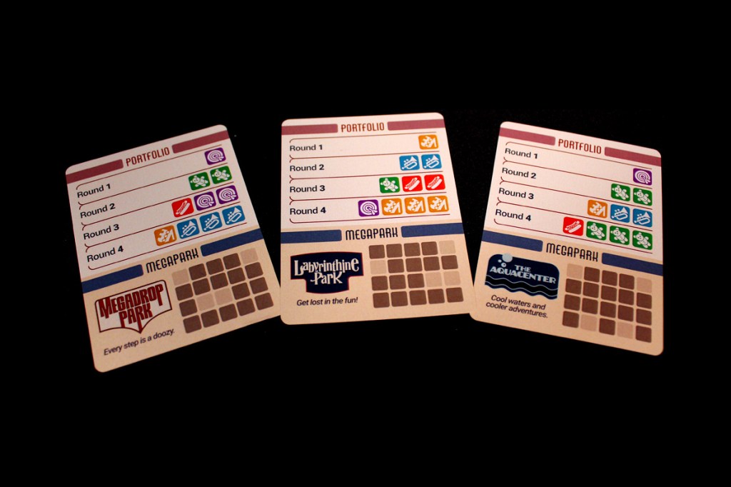 Three cards from the game Lands of Amazement, showcasing different parks and their corresponding Portfolios for tracking game progress.