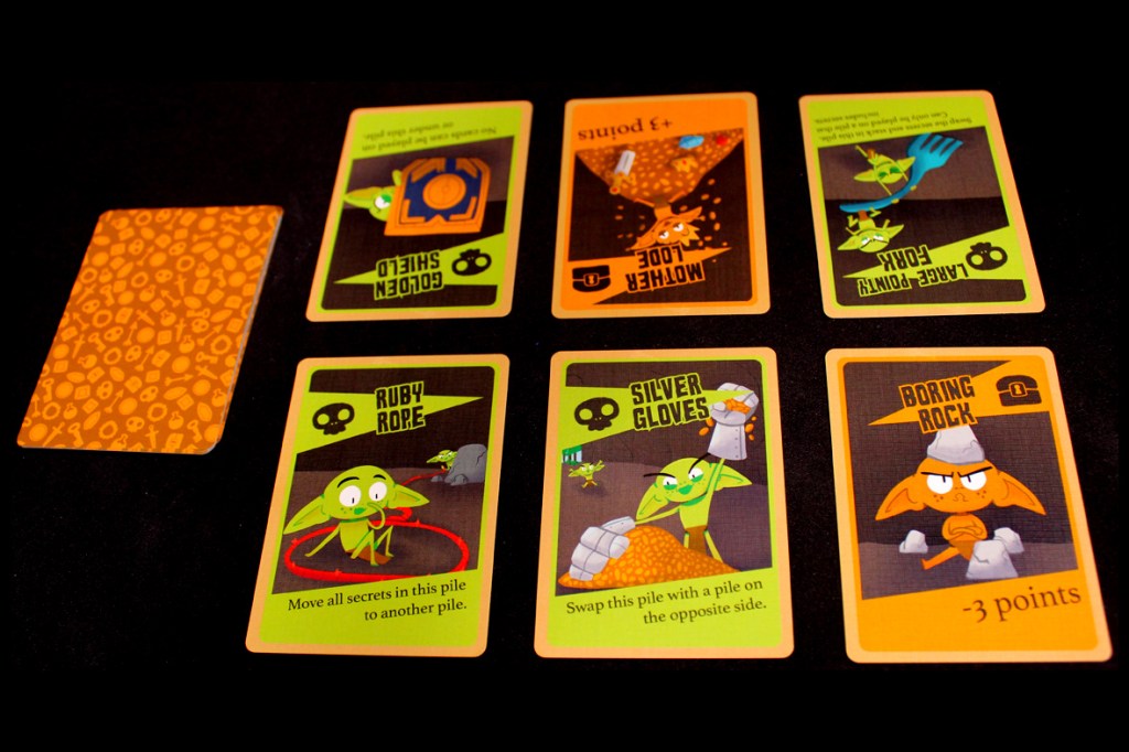A collection of game cards from the board game 'Squabblin Goblins', featuring colorful illustrations of goblins and their items. The cards display various abilities and point values.
