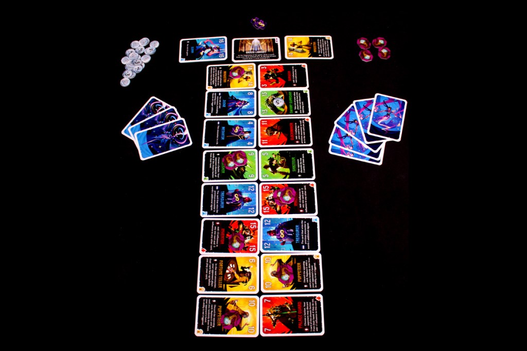 A layout of a two-player card game with various colorful cards arranged in rows, alongside tokens and player boards.