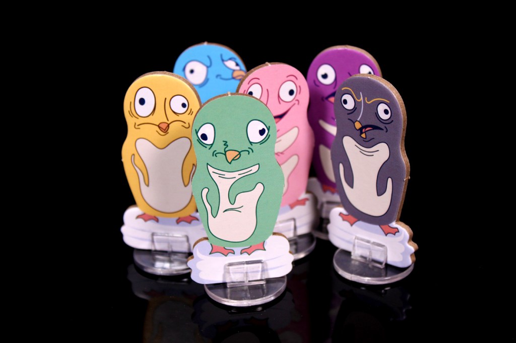Six colorful penguin character tokens with distinct facial expressions, arranged in a semi-circle against a black background.