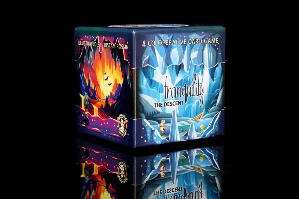 A colorful cube box of the board game 'Tranquility: The Descent' featuring illustrations by Tristam Rossin, depicting a cave and icy landscape against a reflective surface.