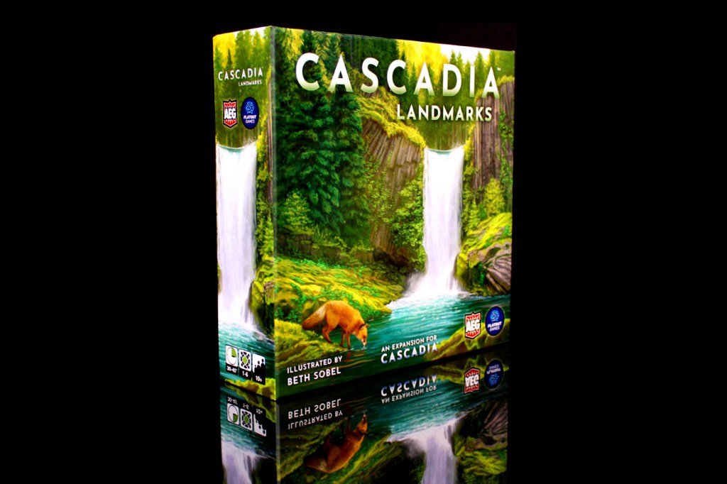 A box of the board game 'Cascadia: Landmarks,' featuring a scenic design with waterfalls, green foliage, and a bear illustration, displayed against a dark background.