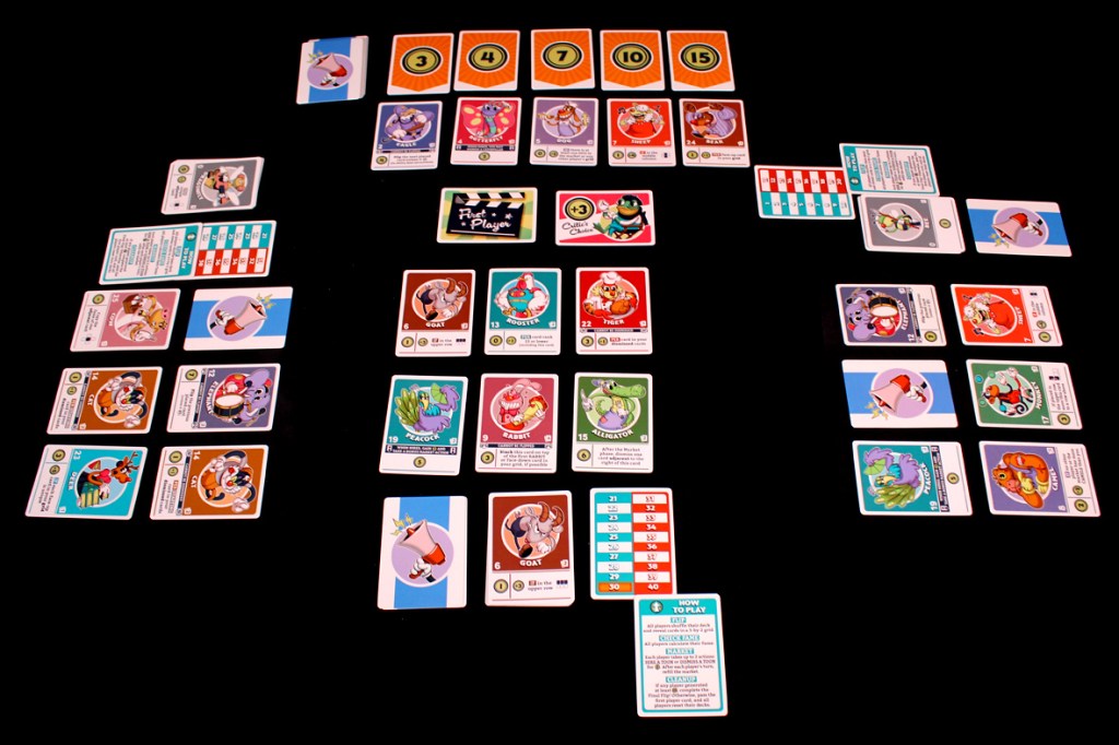 An overview of the board game FlipToons, featuring character cards in a grid layout, a market row with face-up cards, and various player trackers on a black background.