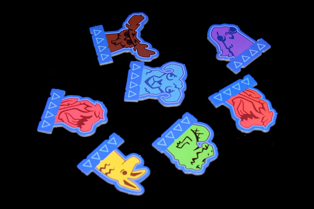 Colorful game tokens featuring various whimsical animal designs for the board game Oddland.