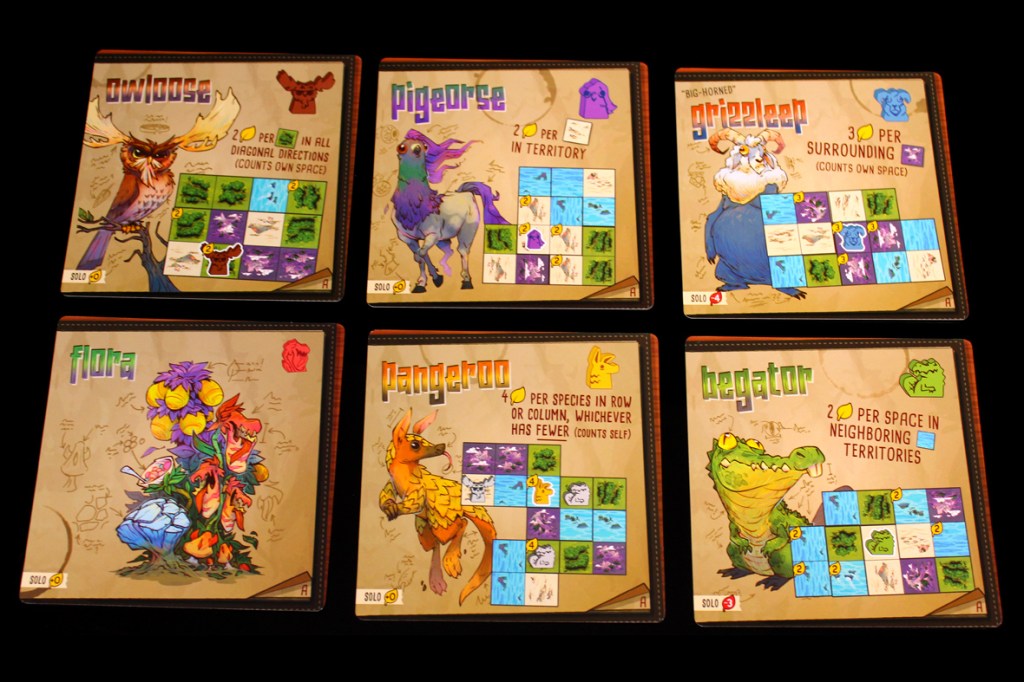 A collection of scoring cards from the board game Oddland, featuring illustrations of various fantastical creatures like owl, pig, ram, and alligator, each with unique scoring rules.
