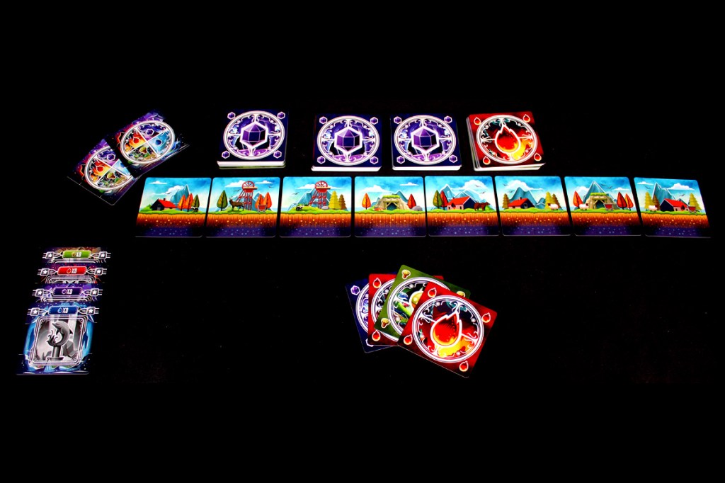 Table setup for the game Tranquility: The Descent, featuring cards with scenic illustrations, elemental symbols, and game tokens arranged in a grid format.