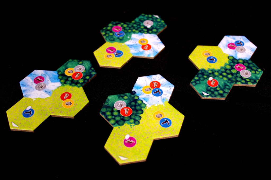 Colorful hexagonal game tiles for Cascadia: Alpine Lakes featuring various symbols and landscapes.
