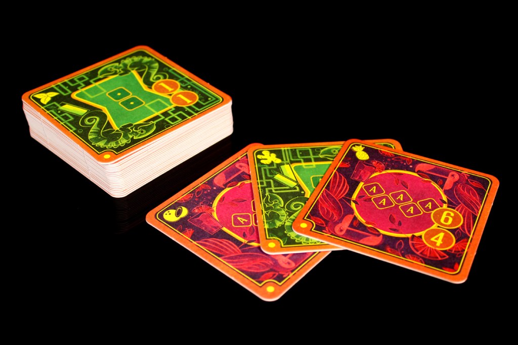 A set of colorful game cards featuring vibrant designs, including symbols and numbers, with a stack of cards in the background.