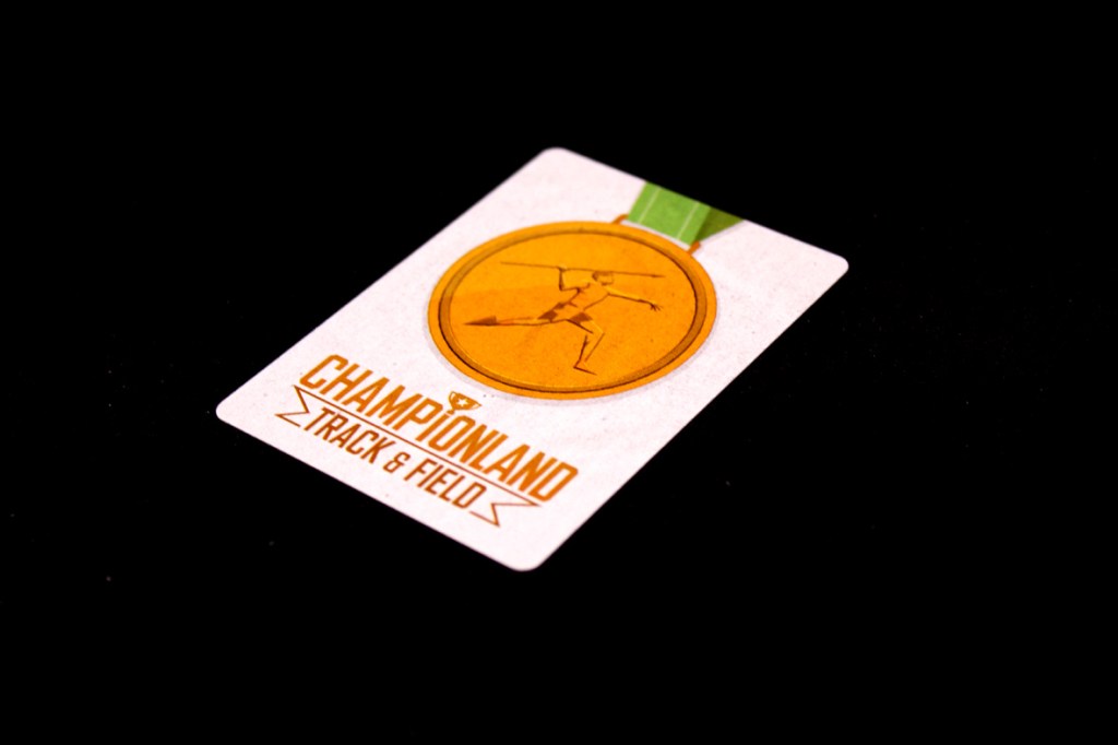 Close-up of a gaming card for 'Championland: Track & Field' featuring a medal design with an athlete in motion.