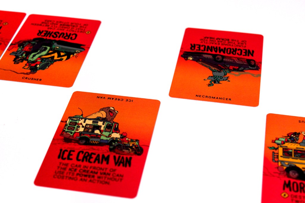 Four game cards from Dustbiters: Pocket Edition featuring colorful artwork, including 'Ice Cream Van', 'Crusher', and 'Necromancer', arranged face up on a white surface.