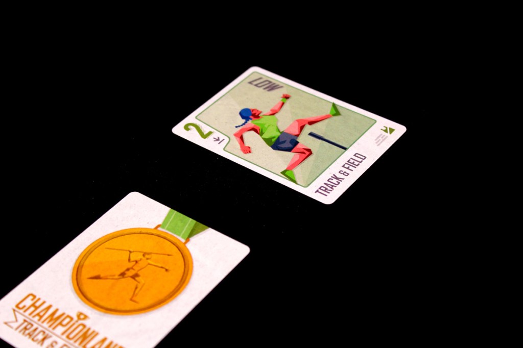 Two game cards from Championland: Track & Field. One card features a character in a track and field pose, while the other showcases a medal with an athlete figure.