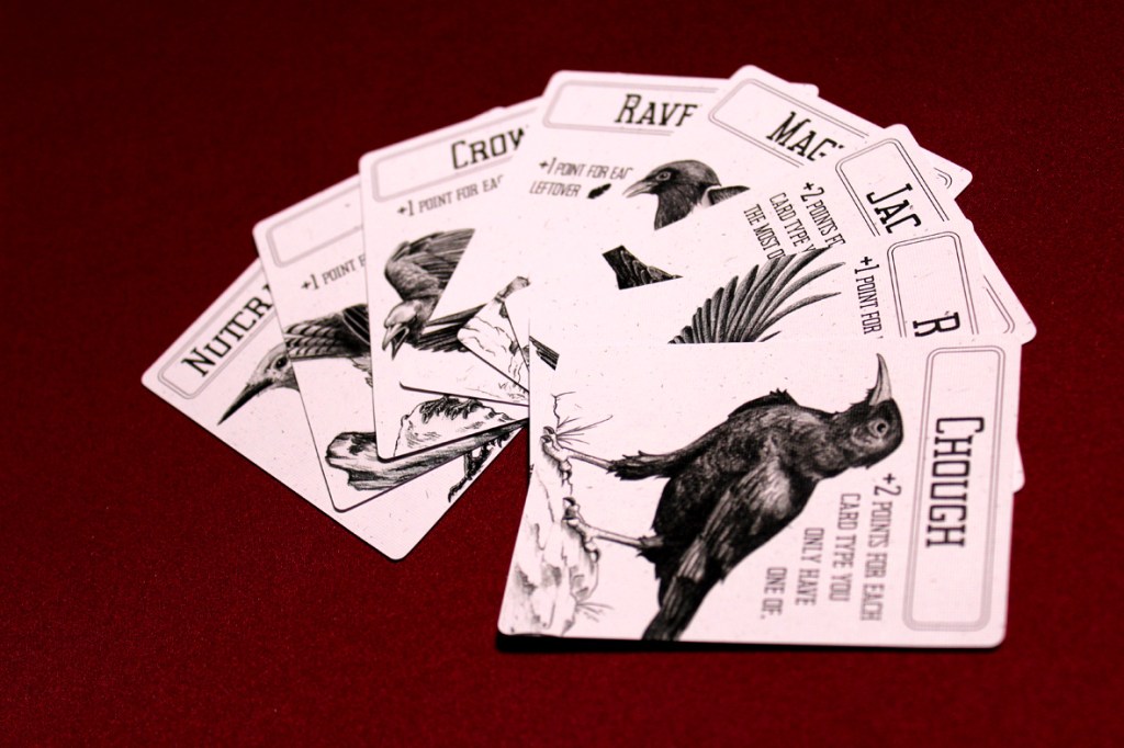 A collection of illustrated game cards featuring various bird types and their point values, laid out on a red background.