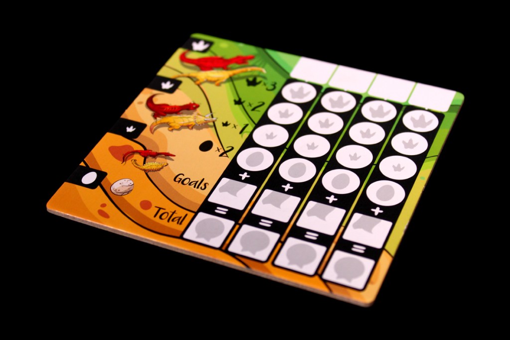 A game board for the board game Chomp, featuring scoring areas for goals and totals, decorated with colorful dinosaur illustrations.