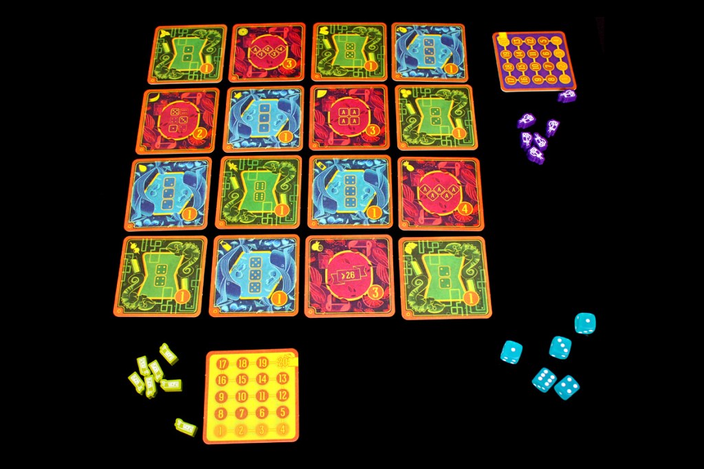 An overhead view of the board game Piña Coladice showing a 4x4 grid of colorful coasters, each labeled with numbers and symbols, alongside player tokens and dice.