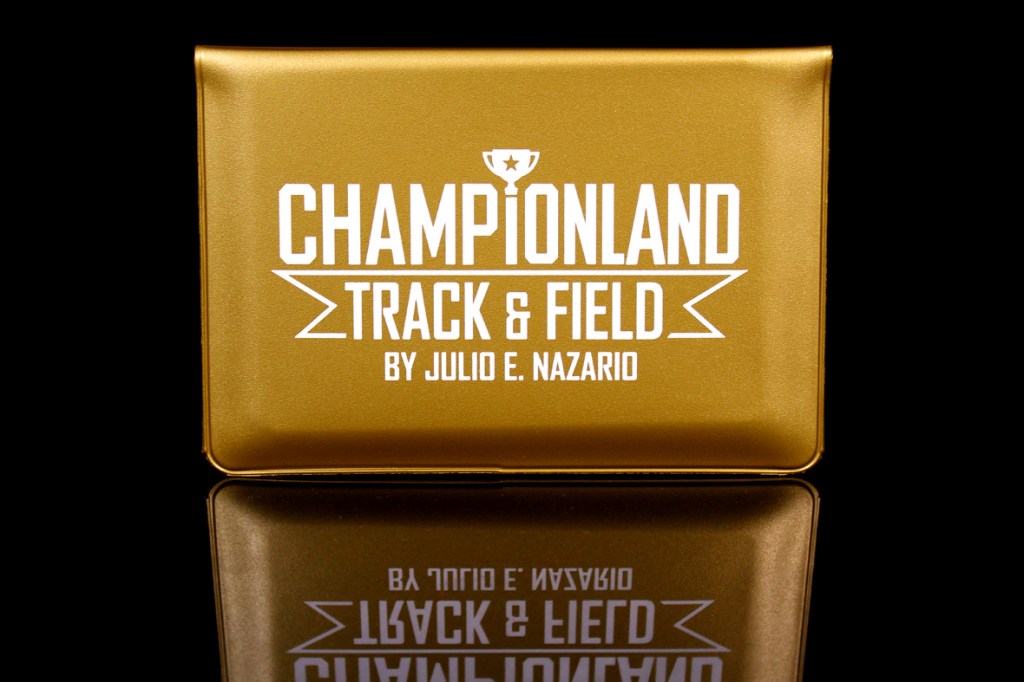 A gold wallet with the text 'CHAMPIONLAND TRACK & FIELD BY JULIO E. NAZARIO' printed in white on its surface.