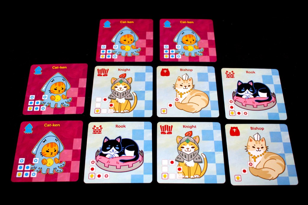 A flat lay of game cards from Cat's Gambit: Queen Aurelia, featuring playful illustrations of cat characters as chess pieces, including Cat-kens, Knights, Bishops, and Rooks, arranged on a checkerboard background.