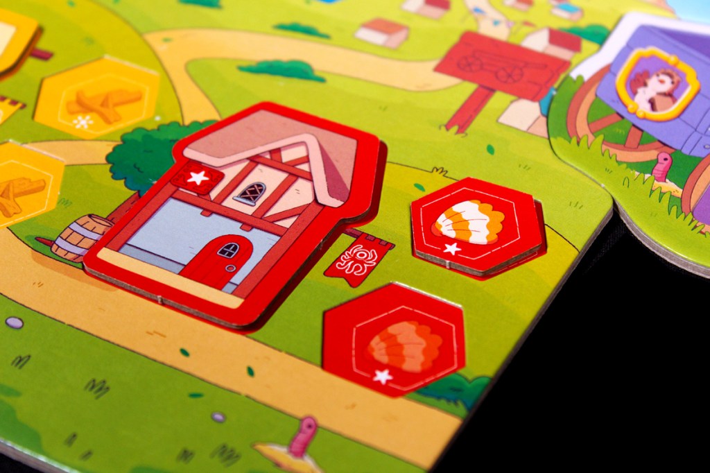 Close-up of an illustrated board game with colorful graphics, featuring a red house token, hexagonal tokens, and a green landscape background.
