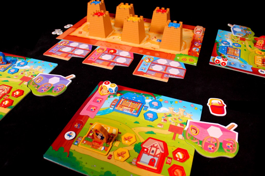 A colorful board game setup featuring various player boards and pieces, including buildings and tokens. The game has a playful design with bright graphics and thematic elements.