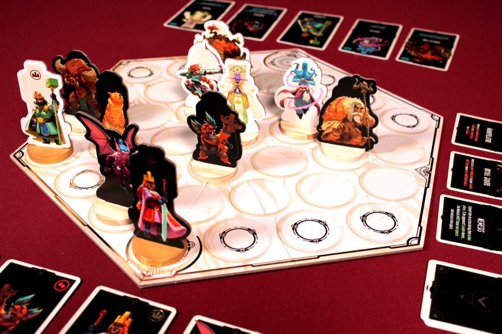 A tabletop game setup featuring colorful character tokens on a hexagonal board with various ability cards displayed at the sides.