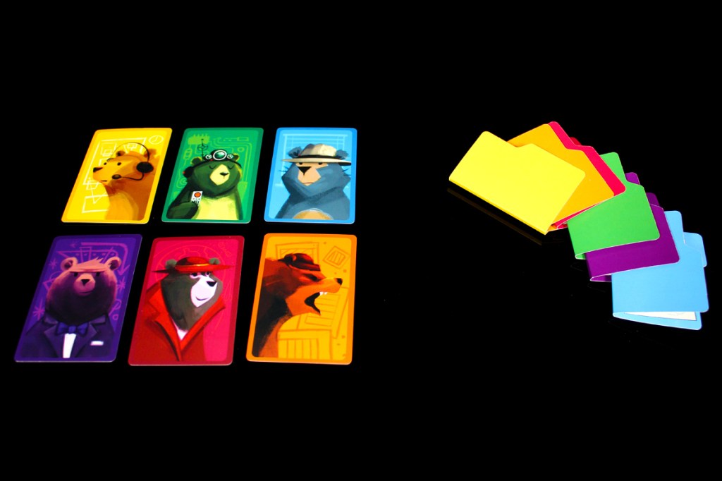 A collection of six colorful playing cards featuring illustrated bears in various styles and outfits, arranged in two rows. Next to the cards, there are five colorful folders in yellow, pink, green, purple, and blue, all against a black background.