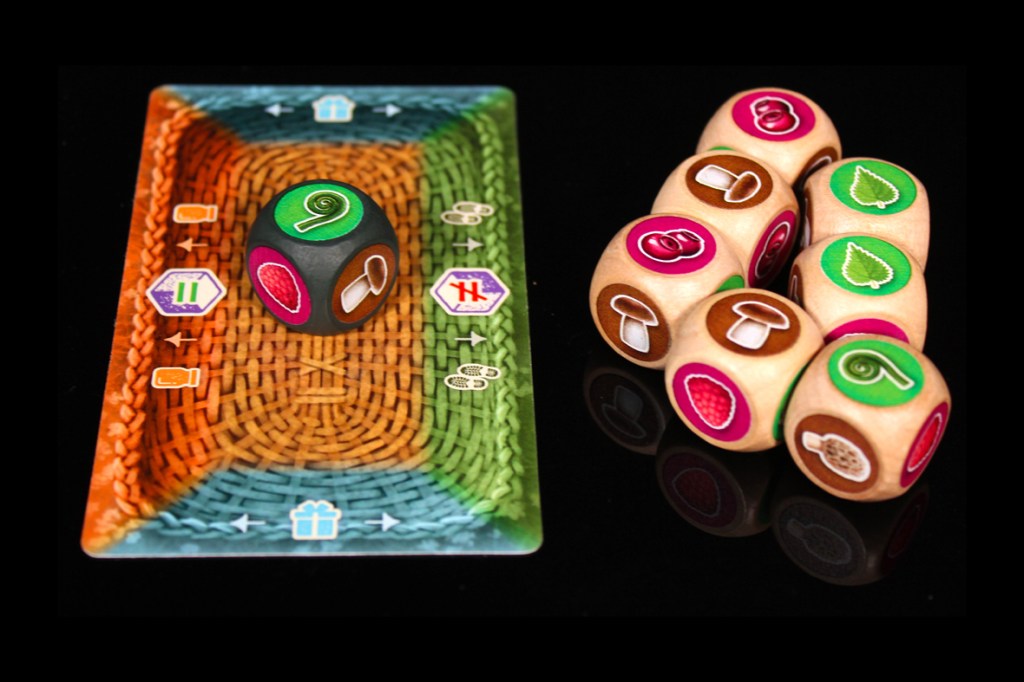 A colorful game board with a central die displaying various fruit and vegetable icons alongside several wooden dice with similar designs.
