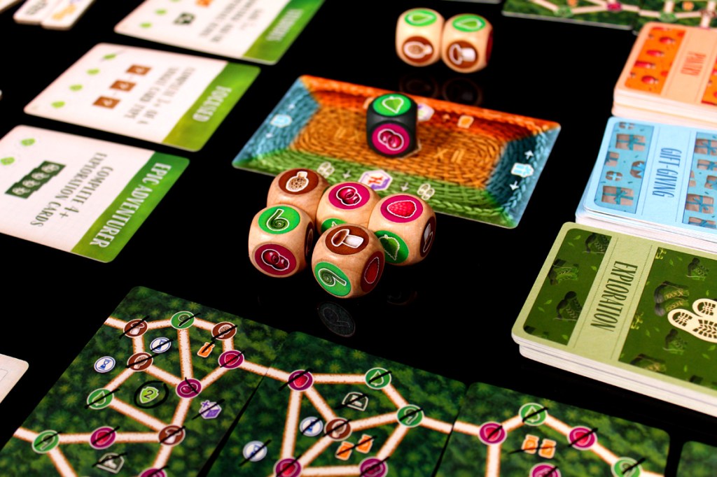 Close-up of a tabletop board game featuring dice, game cards, and a colorful game board setup.