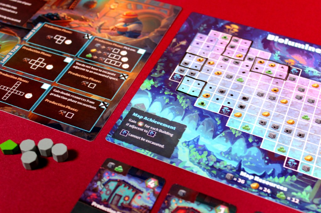 A close-up of a board game layout, featuring elements like resource tokens, a game board with a grid design, and various game cards. The board displays a bioluminescent theme, showcasing different colors and symbols related to gameplay mechanics.