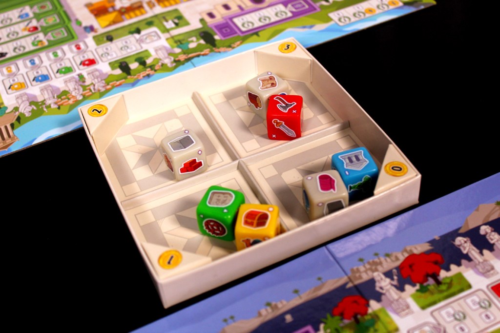 A close-up view of a board game setup featuring colorful dice in a tray, with a detailed game board visible in the background.