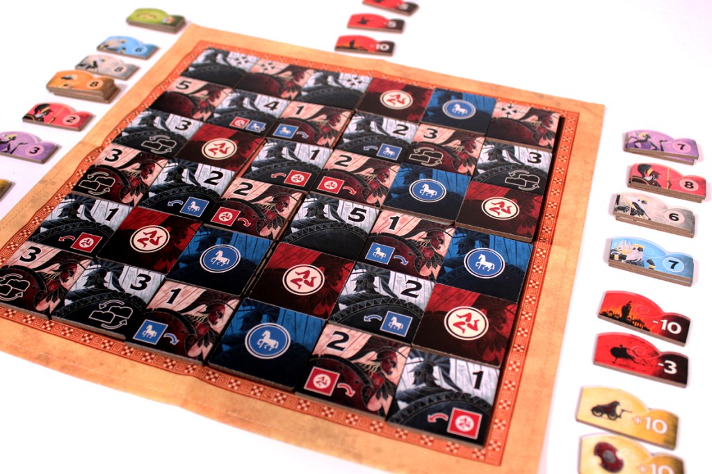 A colorful board game layout featuring a grid of tiles with various symbols and numbers, along with several tokens or pieces arranged at the edges.