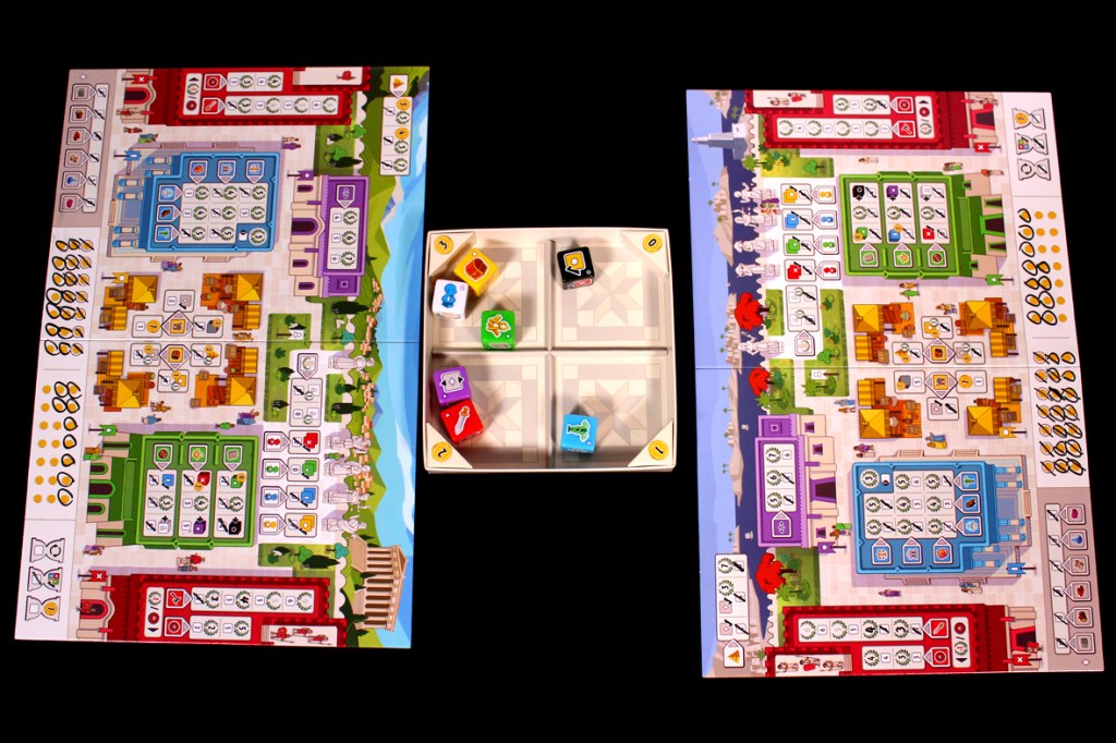 A tabletop game setup featuring two large boards with various icons and gameplay elements, including a central component with colored dice placed in compartments.