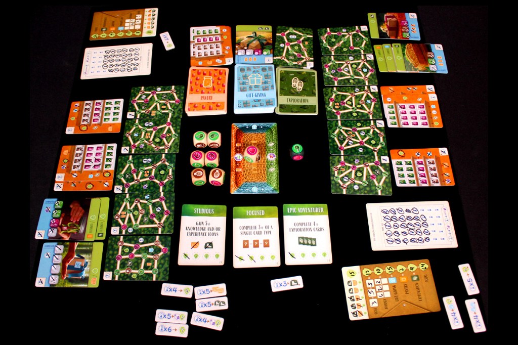 A tabletop game layout featuring various cards, tokens, and a game board, displayed on a black surface.