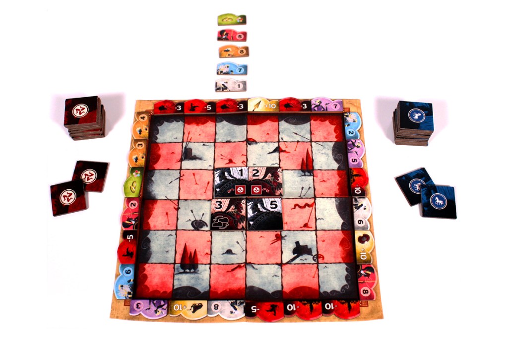 A colorful board game setup featuring a square game board with various numbered tiles and symbols, accompanied by stacks of game tokens and cards arranged around the board.